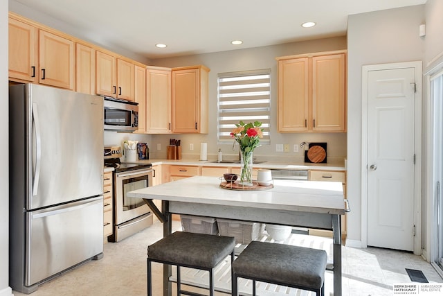 kitchen with appliances with stainless steel finishes, sink, and light brown cabinets