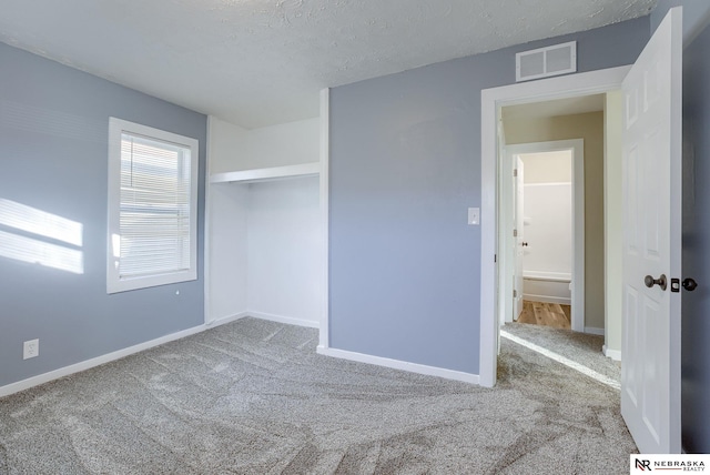 carpeted empty room with a textured ceiling