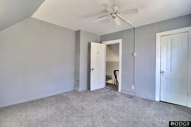 unfurnished bedroom featuring carpet floors, ceiling fan, and vaulted ceiling