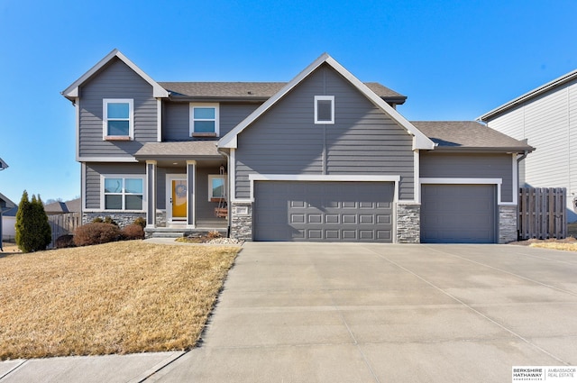 craftsman inspired home with a garage and a front yard