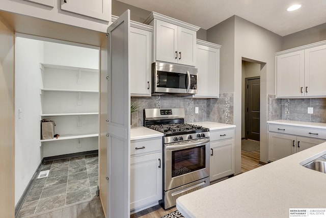 kitchen with white cabinetry, tasteful backsplash, and stainless steel appliances