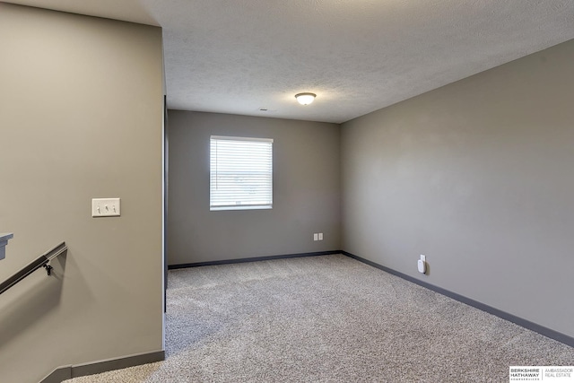 carpeted empty room featuring a textured ceiling