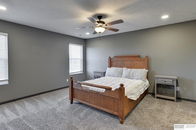 carpeted bedroom featuring ceiling fan and a textured ceiling