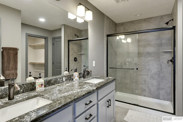 bathroom with vanity, tile patterned flooring, and a shower with door