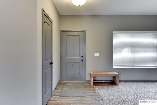 foyer entrance featuring a textured ceiling and light wood-type flooring