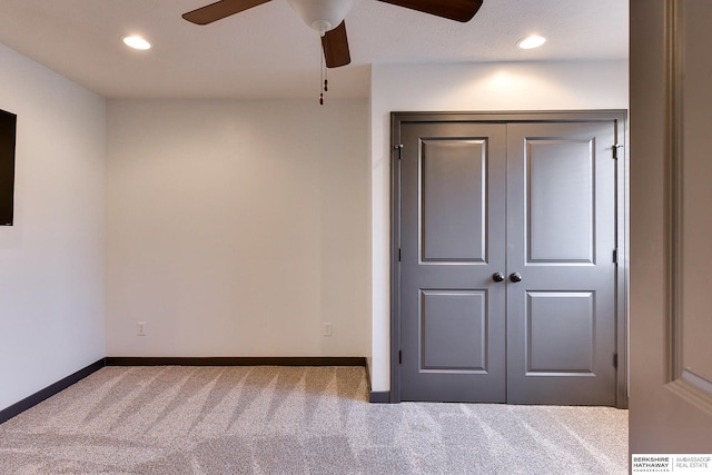 unfurnished bedroom featuring a closet, ceiling fan, and carpet flooring