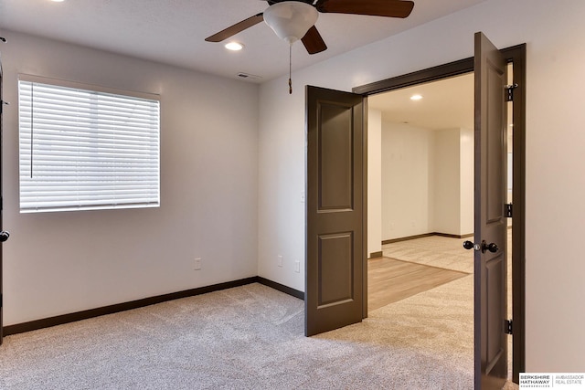 unfurnished bedroom featuring light colored carpet and ceiling fan