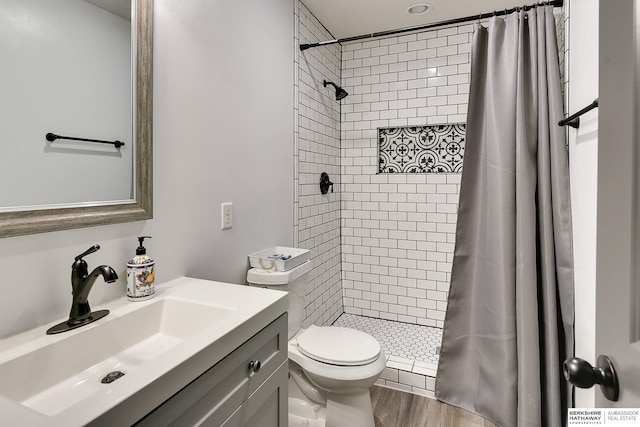 bathroom featuring walk in shower, wood-type flooring, toilet, and vanity