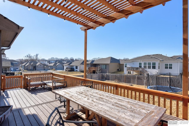 wooden deck with a trampoline and a pergola