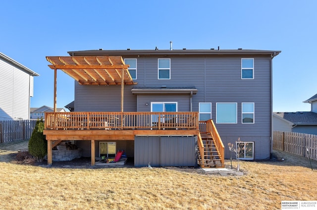 rear view of house featuring a wooden deck and a lawn