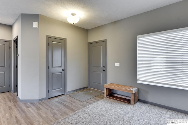 foyer with a textured ceiling and light wood-type flooring