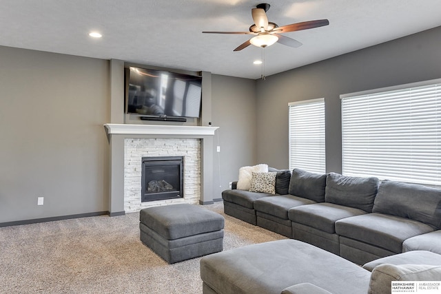 living room with ceiling fan, carpet floors, and a fireplace