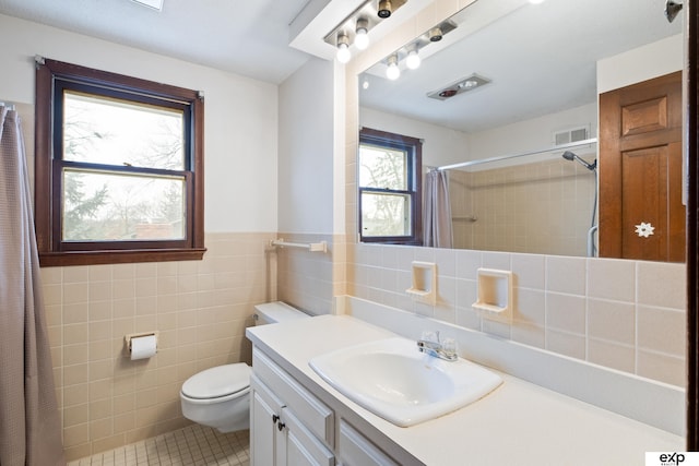 bathroom featuring tile walls, vanity, walk in shower, toilet, and tile patterned floors