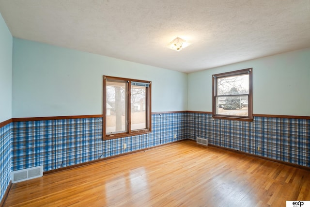 unfurnished room featuring hardwood / wood-style floors and a textured ceiling