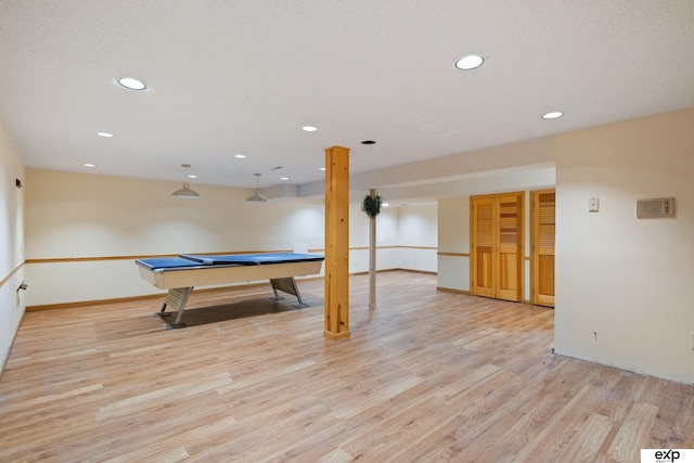 recreation room with a textured ceiling and light wood-type flooring