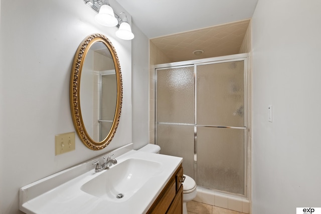 bathroom featuring vanity, a shower with shower door, and toilet