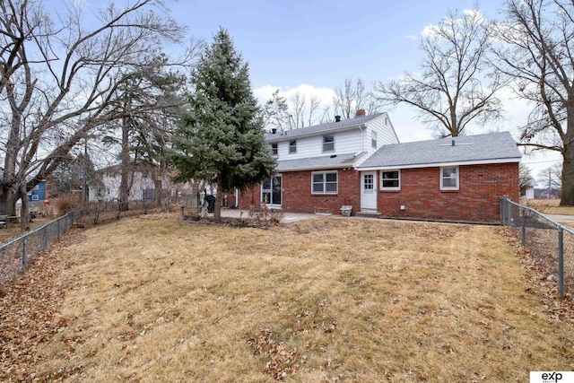 rear view of house with a lawn and a patio