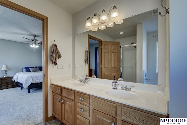 bathroom featuring vanity, a textured ceiling, a shower with door, and ceiling fan