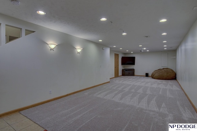 basement featuring light carpet and a textured ceiling