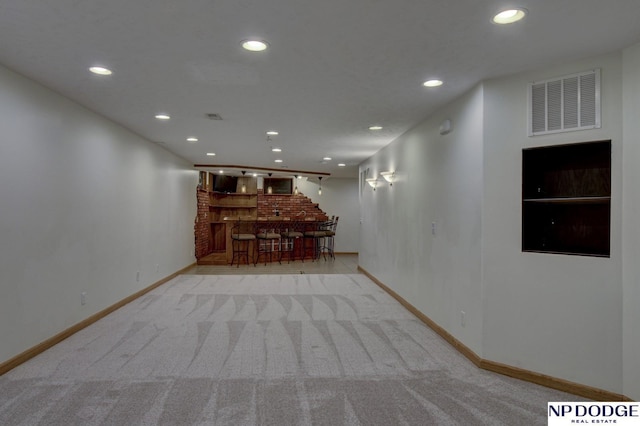 hall with light colored carpet