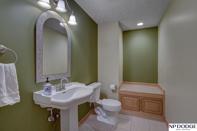 bathroom with tile patterned flooring, a textured ceiling, and toilet