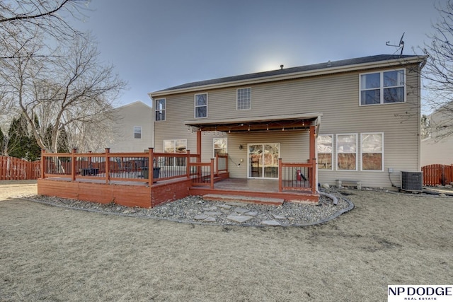 rear view of house with a wooden deck, a yard, and cooling unit