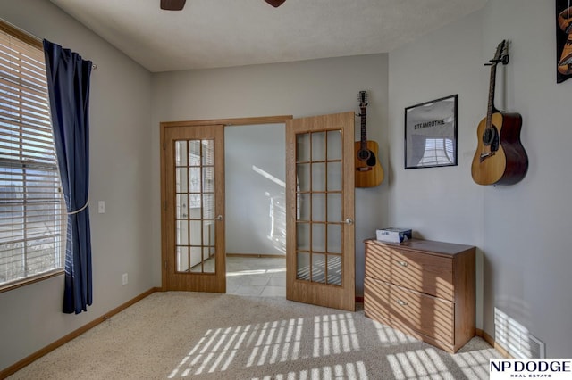 doorway to outside featuring light colored carpet, french doors, and ceiling fan