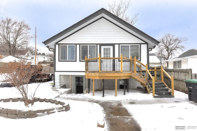 snow covered rear of property featuring a deck