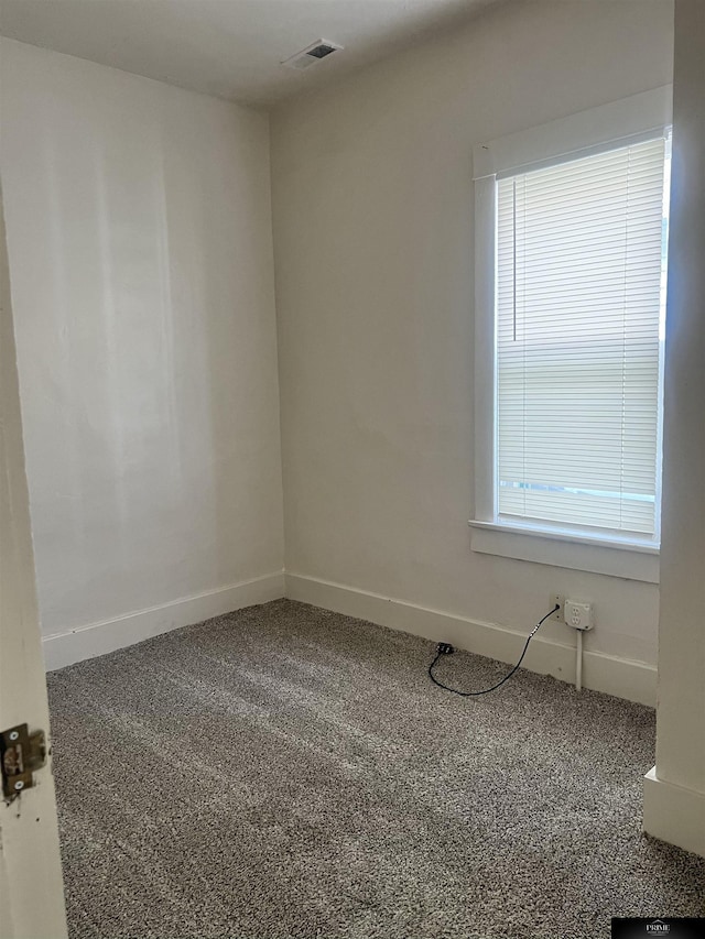 carpeted spare room with baseboards and visible vents