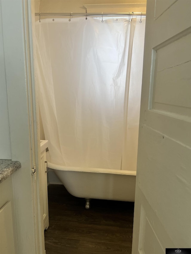 full bathroom featuring wood finished floors, vanity, and shower / tub combo with curtain