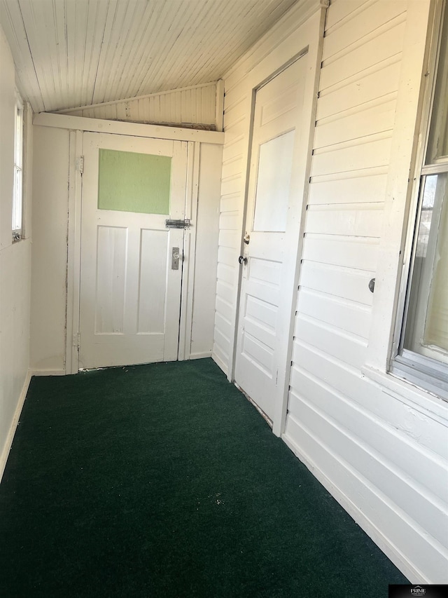 interior space with carpet floors, wood ceiling, wooden walls, and vaulted ceiling