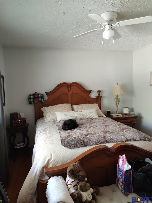 bedroom with ceiling fan and a textured ceiling