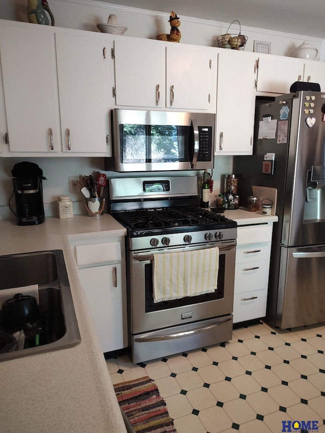 kitchen with stainless steel appliances, white cabinetry, sink, and crown molding