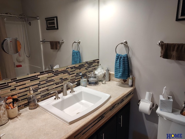 bathroom featuring vanity, backsplash, a shower, and toilet