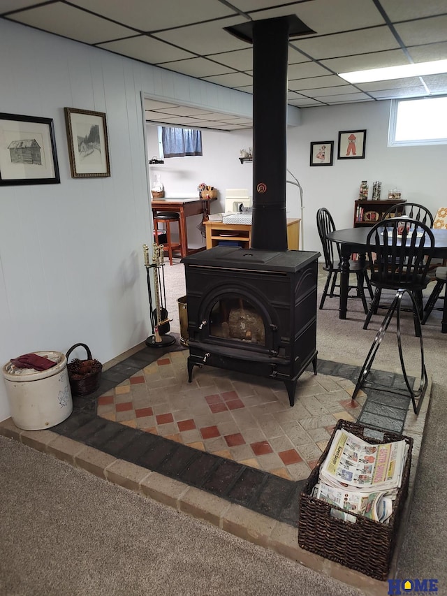 interior space featuring a wood stove and a drop ceiling