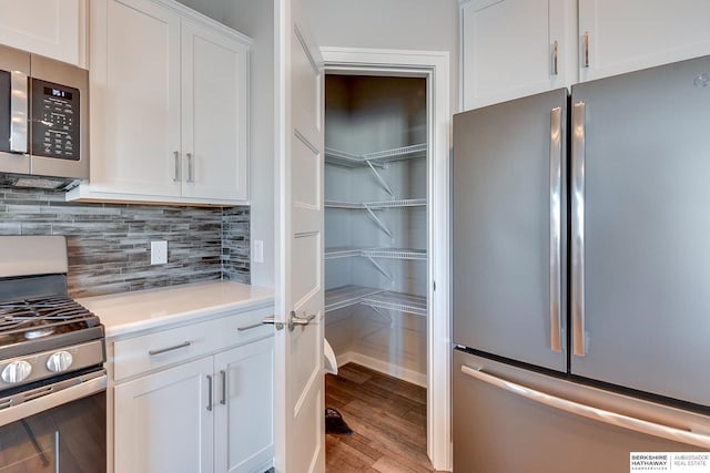 kitchen featuring tasteful backsplash, white cabinetry, appliances with stainless steel finishes, and light hardwood / wood-style flooring