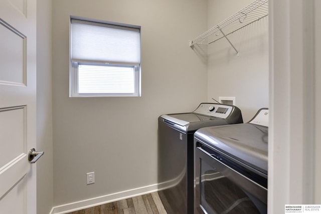 laundry room with wood-type flooring and washer and dryer