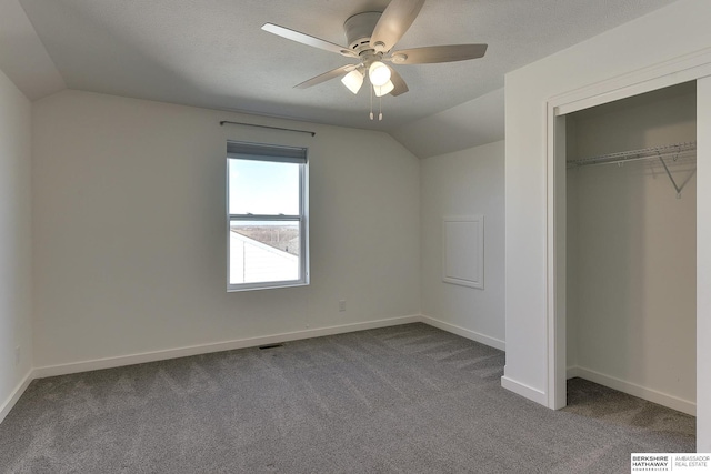 unfurnished bedroom featuring lofted ceiling, carpet, a closet, and a textured ceiling