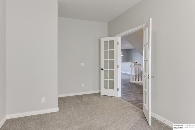 carpeted spare room featuring french doors