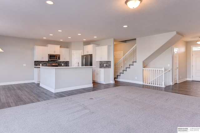 kitchen featuring a kitchen island, white cabinetry, appliances with stainless steel finishes, and backsplash