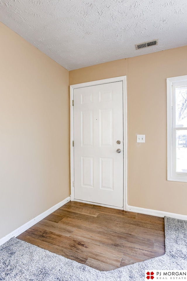 entryway with hardwood / wood-style flooring and a textured ceiling