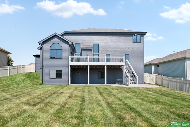 back of house featuring a deck and a lawn