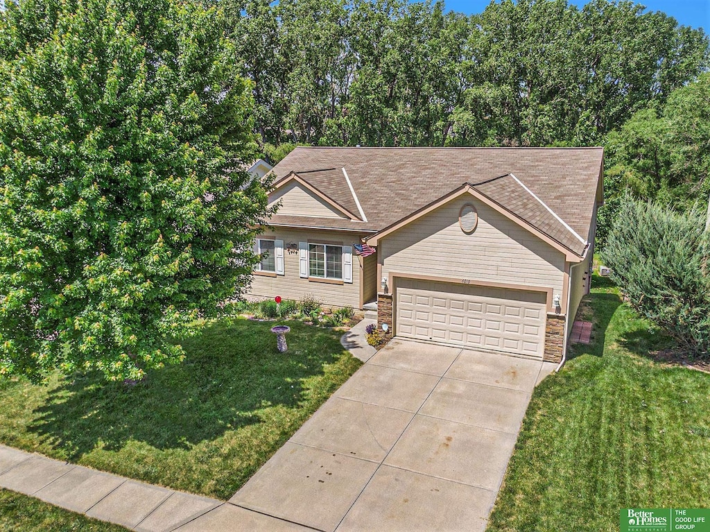 ranch-style house featuring a garage and a front lawn