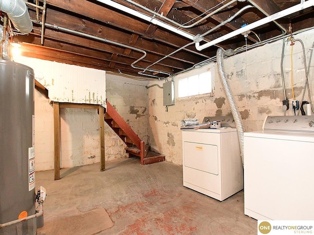 basement featuring washing machine and clothes dryer, electric panel, and gas water heater