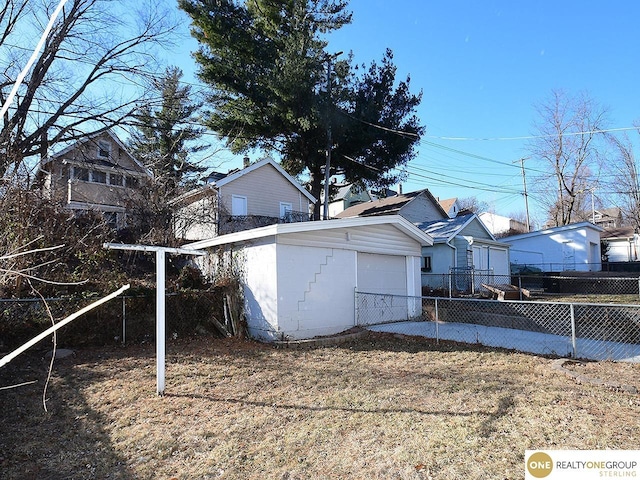 view of side of property featuring a garage, a yard, and an outdoor structure