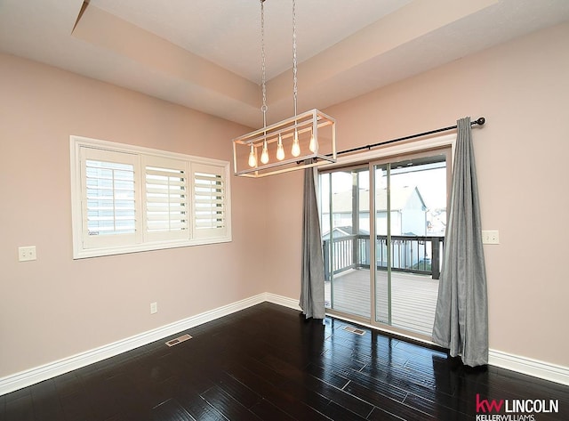 spare room with wood-type flooring and a tray ceiling