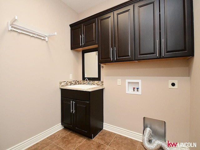 washroom with tile patterned floors, sink, cabinets, washer hookup, and hookup for an electric dryer