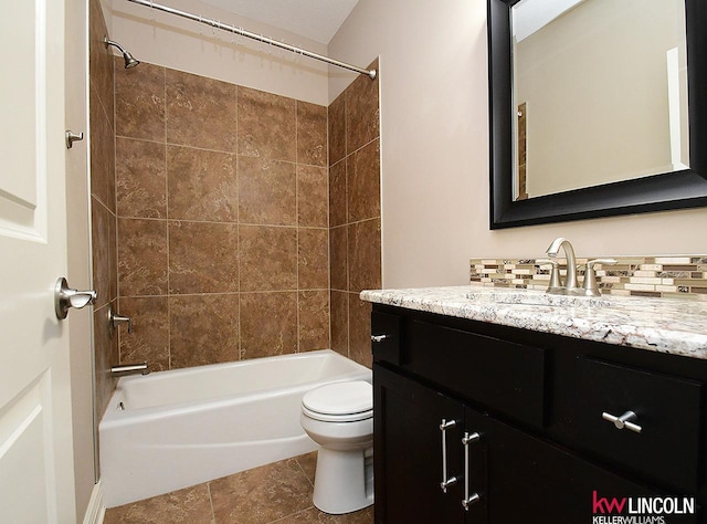 full bathroom featuring tiled shower / bath, vanity, toilet, and tile patterned flooring