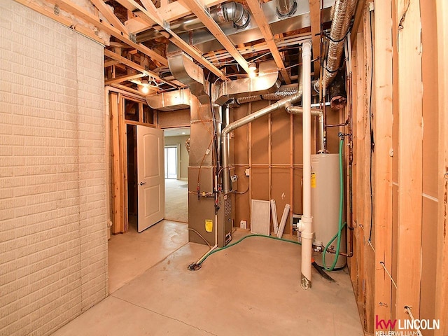 basement featuring heating unit, brick wall, and water heater