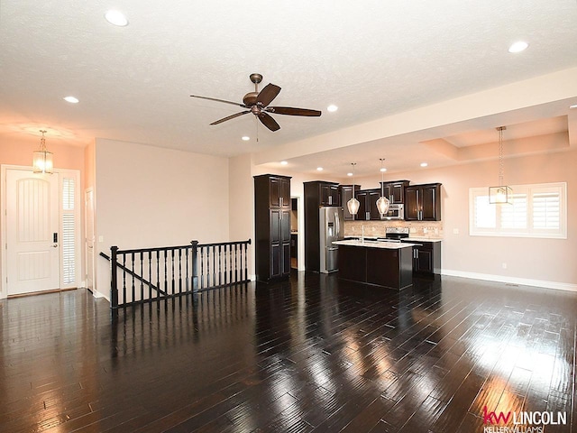 living room with ceiling fan, dark hardwood / wood-style flooring, and a textured ceiling